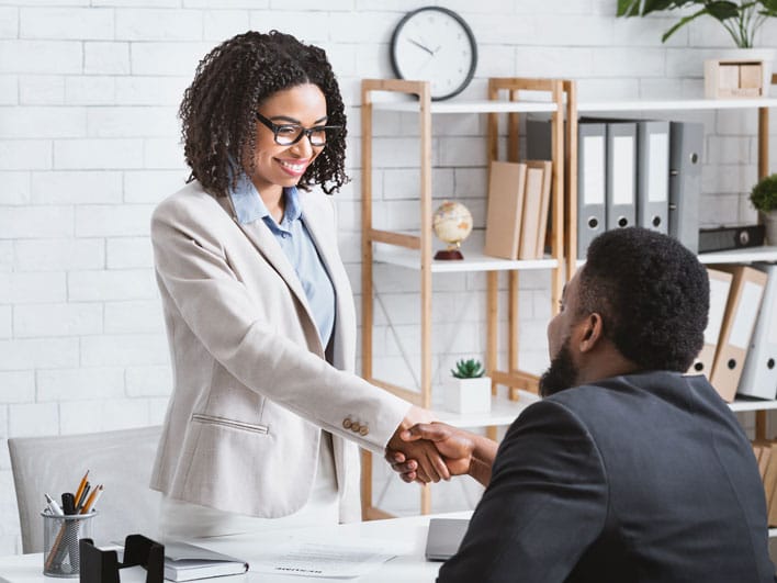hiring manager shaking hands with applicant